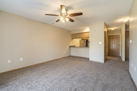 A room with a ceiling fan and carpeted floor.