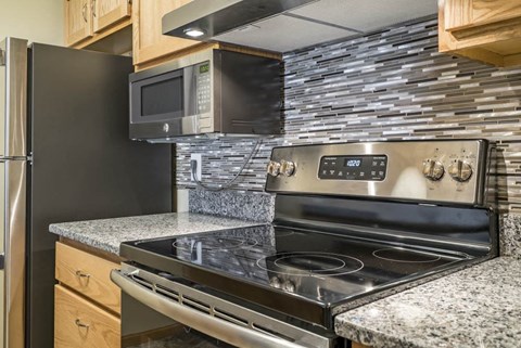 A modern kitchen with a black stove top oven and a black refrigerator.