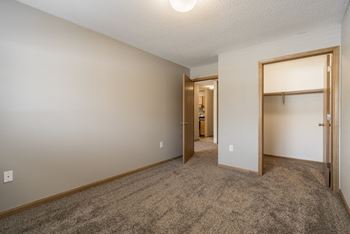 A room with a carpeted floor and a doorway leading to another room.