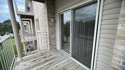 a balcony with a sliding glass door and a metal railing