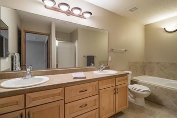 A bathroom with a sink, mirror, and toilet.