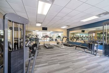 Bright and spacious exercise room featuring cardio machines, free weights, and weightlifting machines at Southwind Villas in LaVista NE 68128
