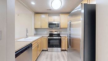 a kitchen with stainless steel appliances and wooden cabinets