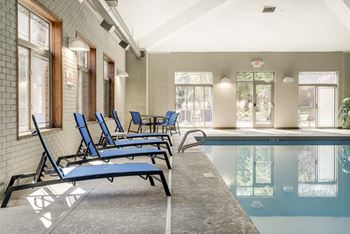 a swimming pool with blue lounge chairs