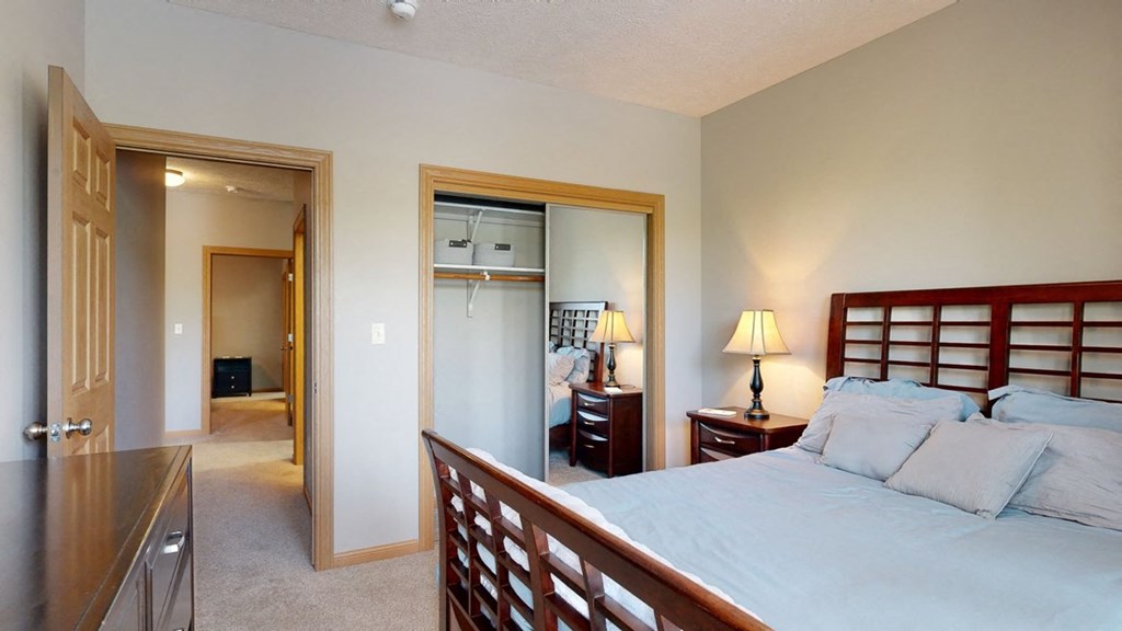 a bedroom with a bed and a mirrored closet door