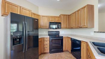 a kitchen with black appliances and wooden cabinets