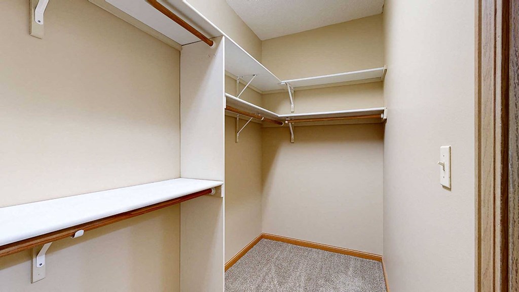 a walk in closet with built-in shelves