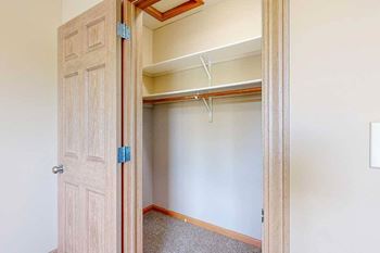 A wide walk-in closet with overhead shelves, and hanging space.
