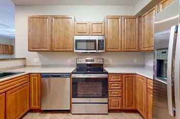 A kitchen with wooden cabinets and stainless steel appliances.
