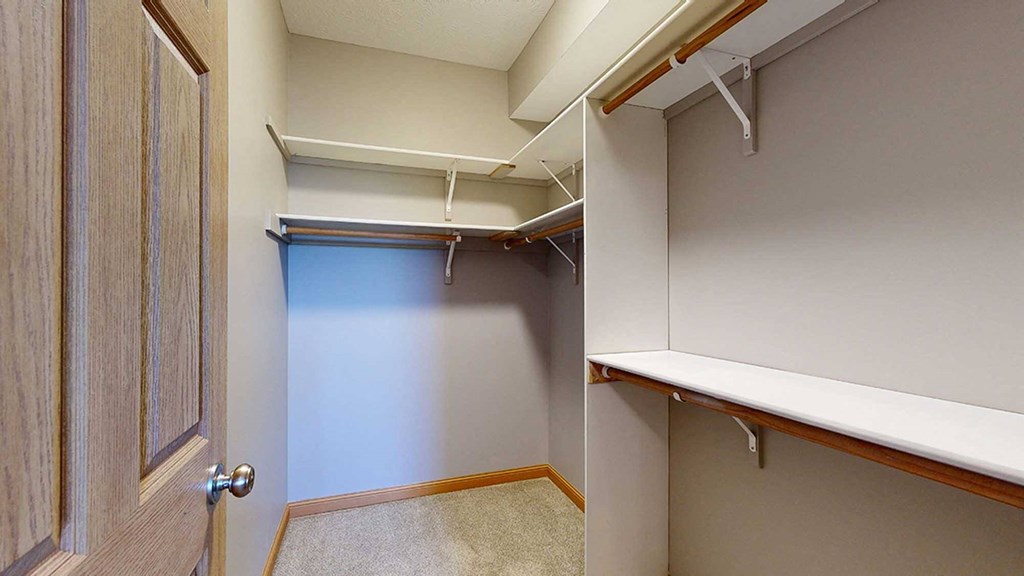 a walk in closet with built-in shelves and hanging space