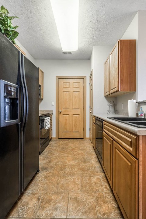a kitchen with a refrigerator and a sink and a door