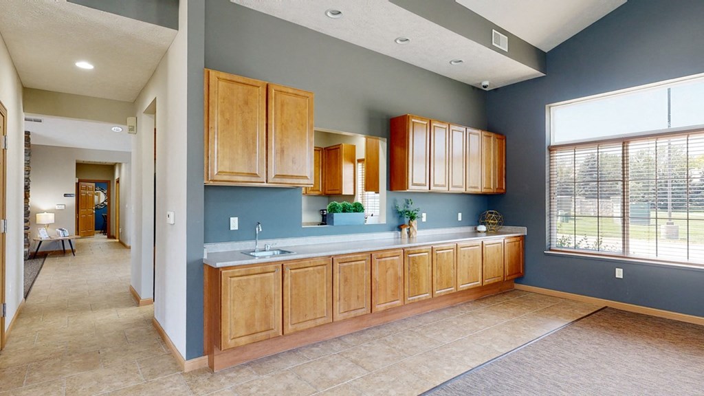 a kitchen with wooden cabinets and a large window