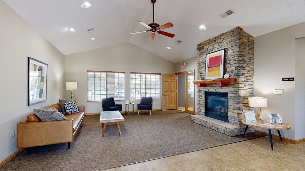 Clubhouse living room with a fireplace and a ceiling fan