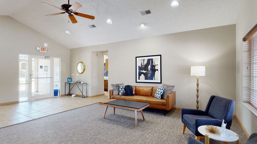 Stone-Ridge-Estates-Clubhouse-Amenities-Lincoln-NE-19 clubhouse living room with a couch coffee table and chair and a ceiling fan