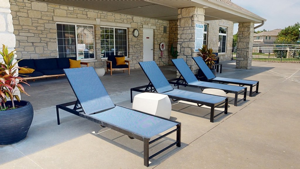 a row of chair loungers are lined up in front of the clubhouse building