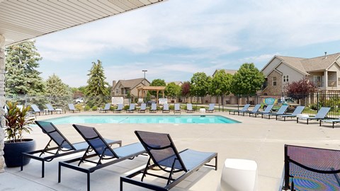 a swimming pool with chaise lounge chairs and trees in the background