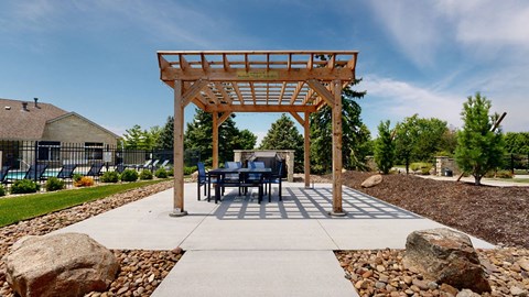a table and chairs under a wooden pergola