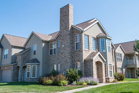a villa building with brick and stone exterior on a sunny day