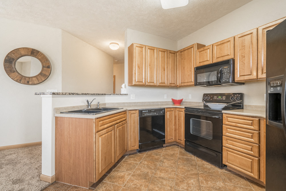 a kitchen with black appliances and wooden cabinets