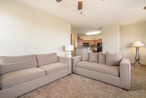 a living room with a couch and a chair and a kitchen