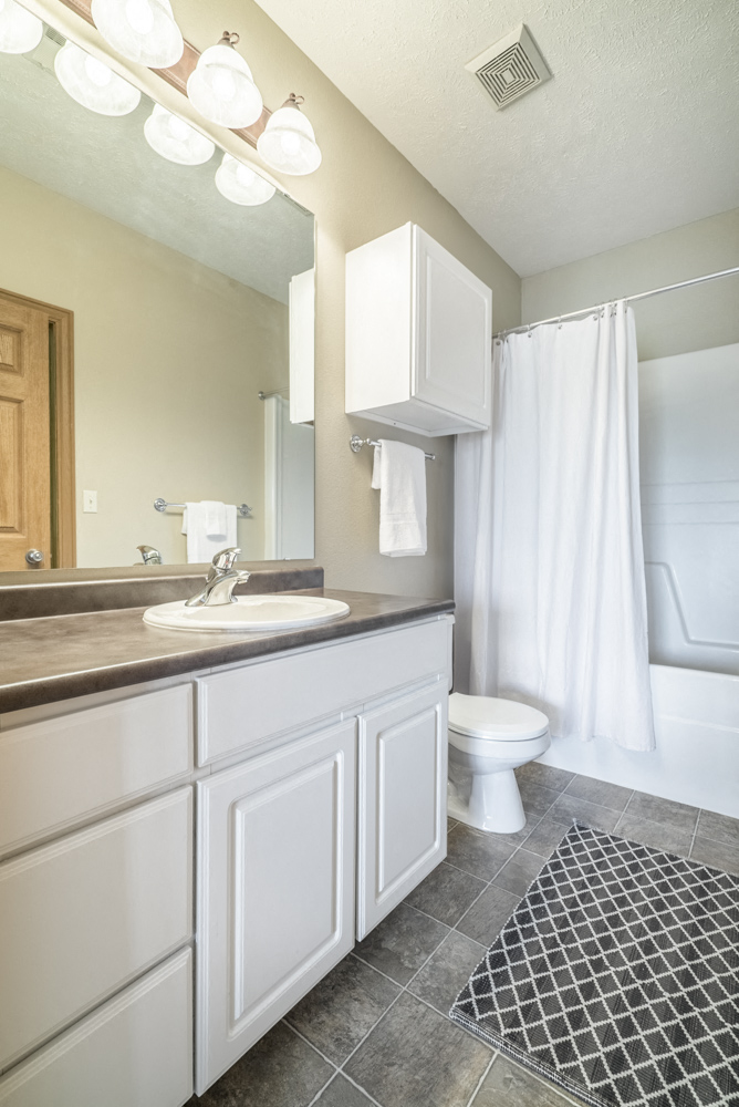 Bathroom with white cabinetry and bathtub at Stone Ridge townhomes in south Lincoln NE