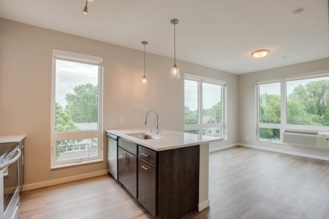 A kitchen with a large island and pendant lights.