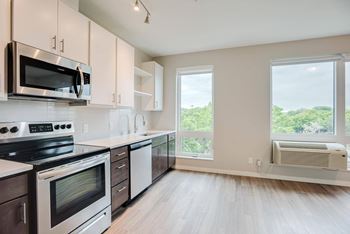 Kitchen with upper and lower cabinets against one wall with stainless steel appliances