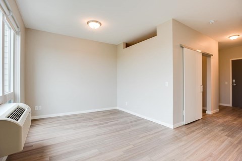 A room with a window and a wall air conditioner