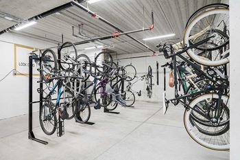 a bike locker room with multiple mounted spaces to hang bikes
