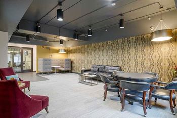 a modern lounge pub room with a patterned wallpaper and a mix seating styles