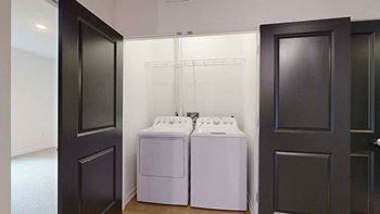 a laundry closet with side-by-side full sized washer and dryer