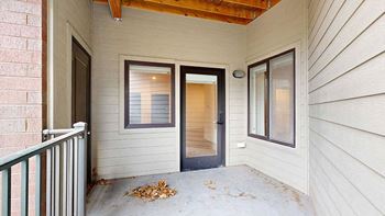 a patio with a glass door and a two windows
