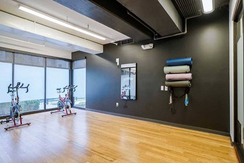 a yoga and spin studio with wooden floors and large windows