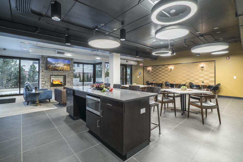 The Conrad clubhouse with kitchen and fireside seating-Blackstone District Omaha NE