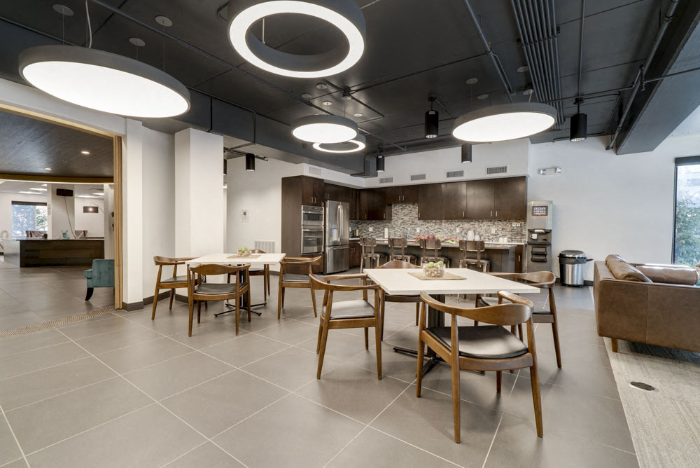 View of clubhouse interior with kitchen and seating at The Conrad near UNMC in the Blackstone District Omaha NE 68105