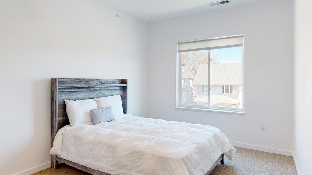 Furnished apartment bedroom with large single window