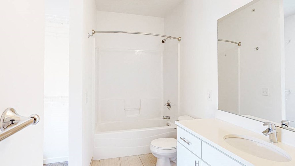 Large bathroom with white cabinetry and large mirror