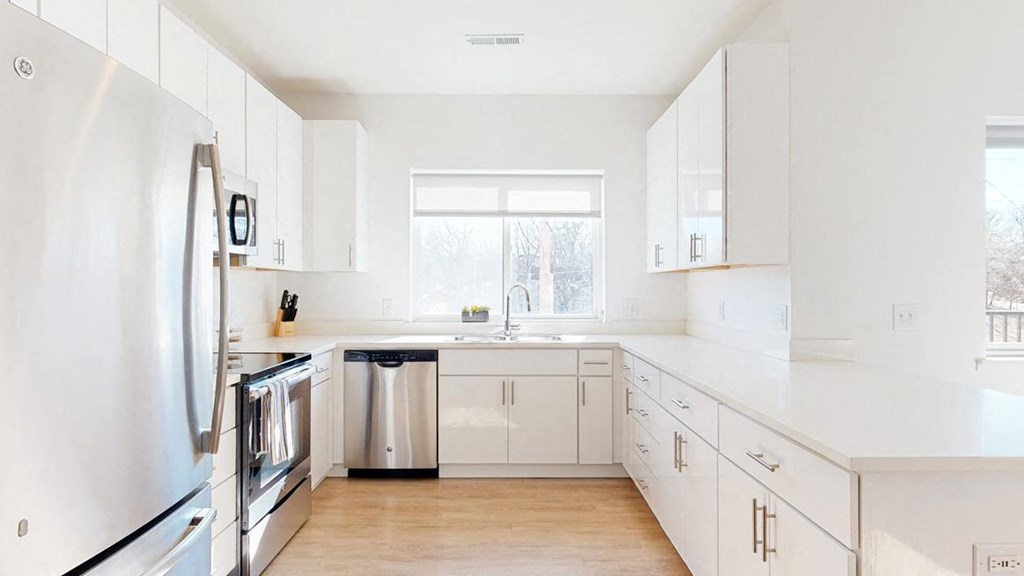 Furnished apartment kitchen with white finish style and stainless steel appliances