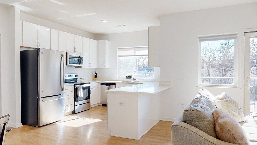 Furnished apartment kitchen with white finish style and stainless steel appliances