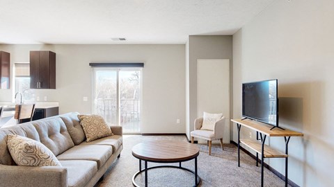 Furnished apartment living room with sofa, lounging chair, and coffee table