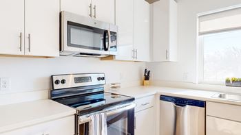 A modern kitchen with a stainless steel stove, oven, and microwave.