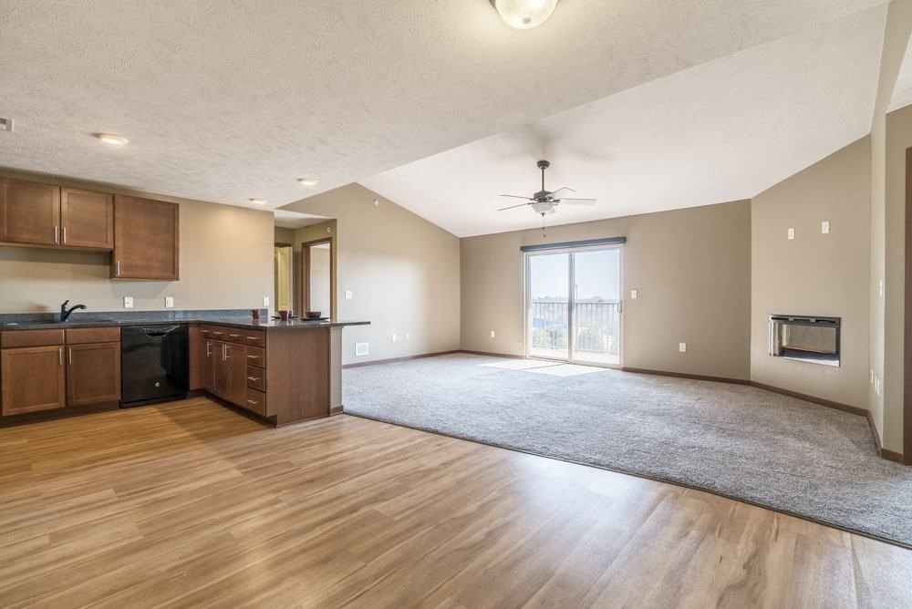 A spacious kitchen with wooden floors and a ceiling fan.