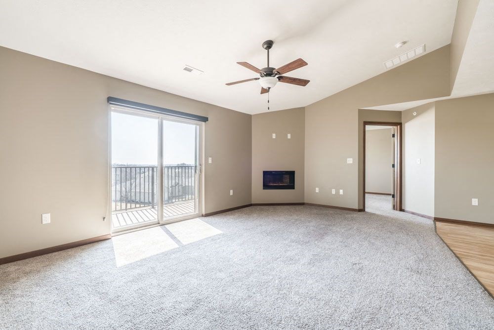 A spacious living room with a fireplace and sliding glass doors.