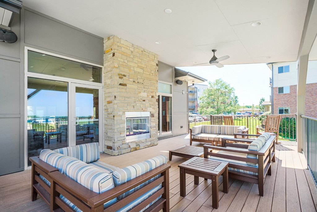 spacious patio with furniture surrounding outdoor stone fireplace