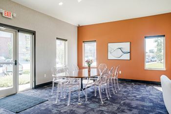 a table and chairs in front of a door in the flats at 84 clubhouse