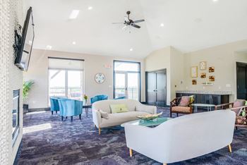 the flats at 84 clubhouse with white couches and blue chairs