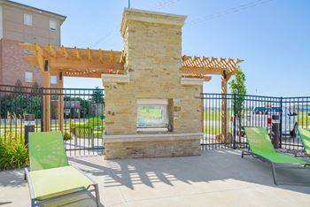 a beautiful patio with lime green lounge chairs next to stone fireplace