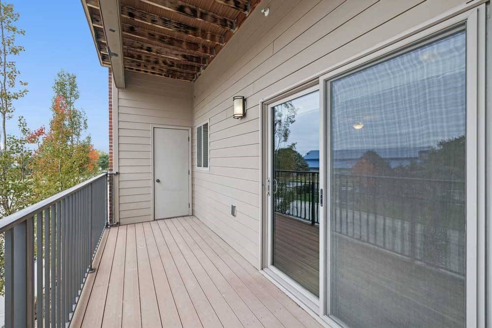 An oversized balcony with a sliding glass door and outdoor storage closet.