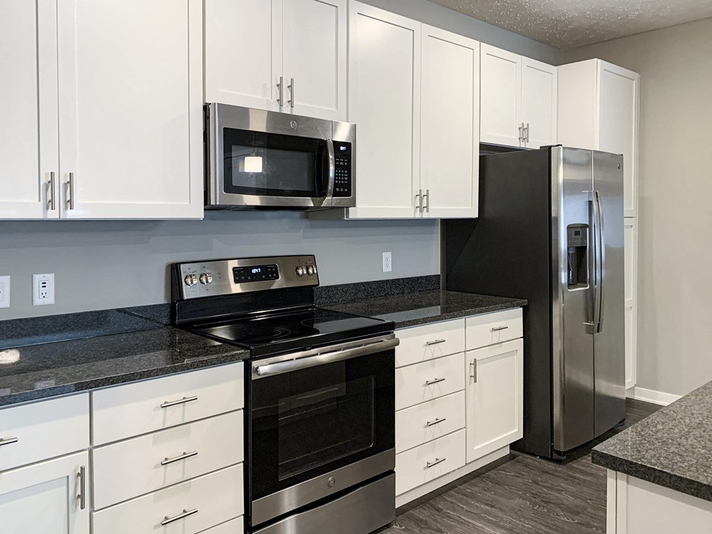 White cabinetry and matching stainless steel appliances in the kitchen of the buffalo floorplan at the flats at shadow creek
