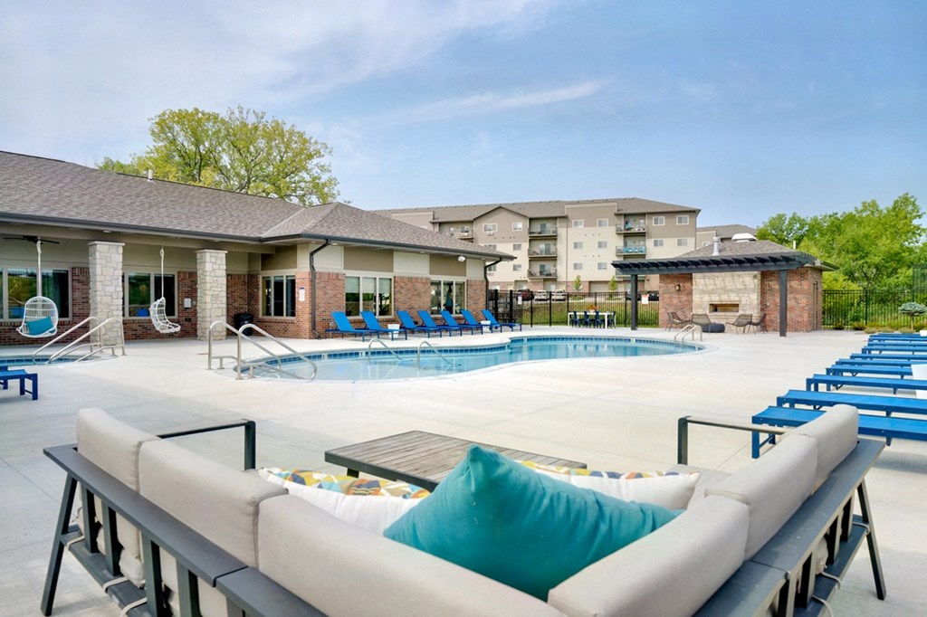 Resort style pool with lounge chairs and couches outside the clubhouse at The Flats at Shadow Creek